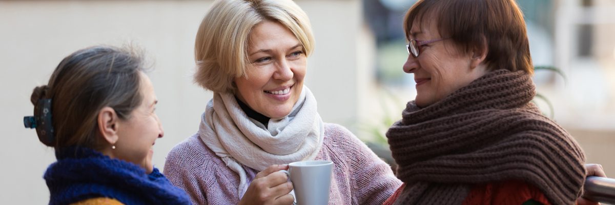 Group of happy mature women drinking tea at balcony